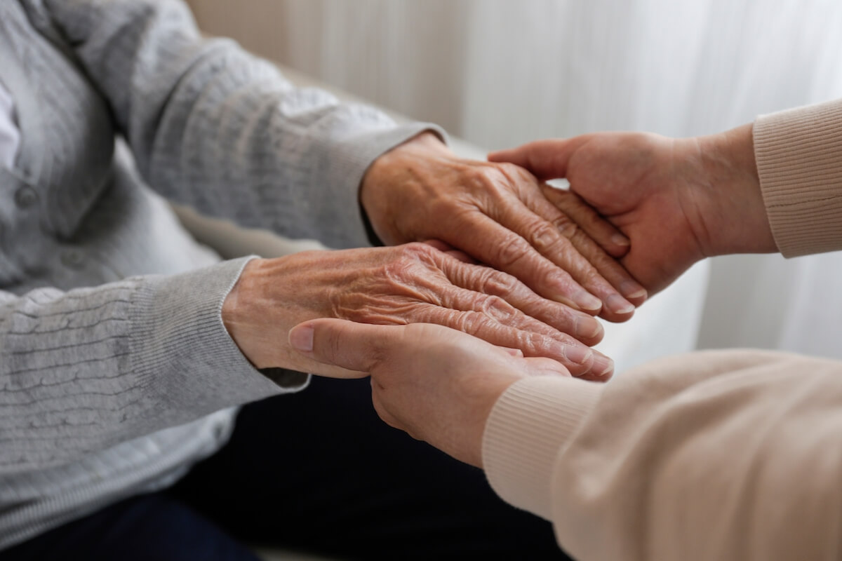 Caregiver holding an old person's hands