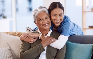 Caregiver hugging an older woman.