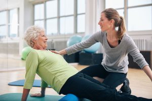 Caregiver helping a resident with her stretching.