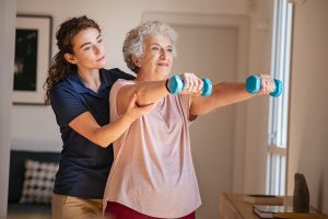 Caregiver exercising with an older woman.