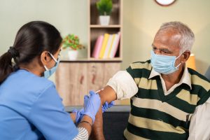 Old man getting vaccinated. 