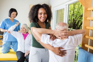 Caregivers helping older adults with their stretching movements