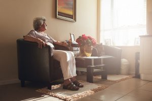 Lonely woman on her couch looking through the window